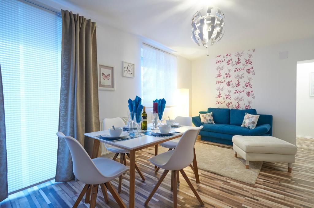 een woonkamer met een tafel en stoelen en een blauwe bank bij Ferienwohnungen Halbturn in Halbturn