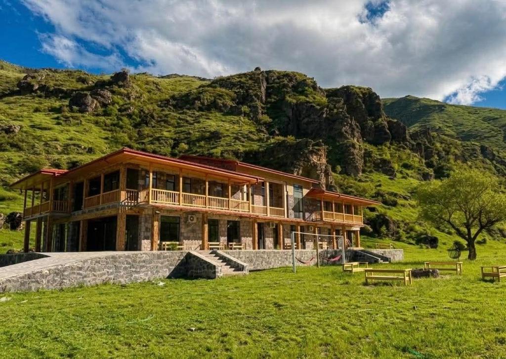 a large house with a mountain in the background at Vardzia Hills in Gogasheni