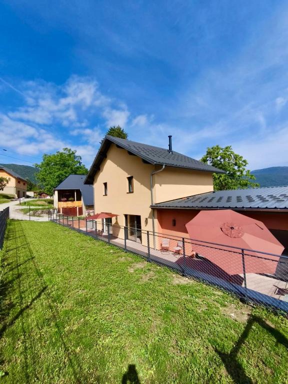 a house with a fence in front of a field at Gîte de la Vonne in Vimines