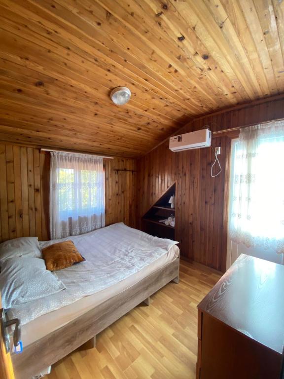 a bedroom with a bed in a wooden room at Silk Way in Ureki