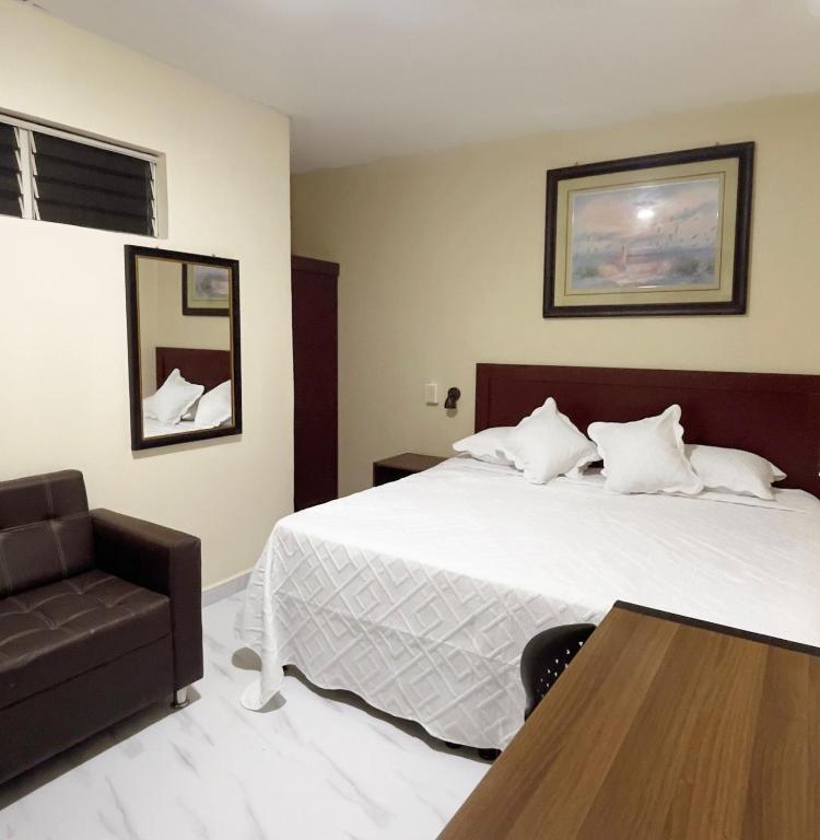 a hotel room with a bed and a chair at Hotel King del Centro San Miguel in San Miguel