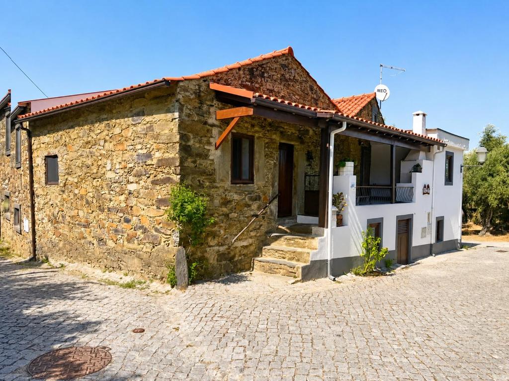 a stone building on a cobblestone street at Casa dos Laia in Sobreira Formosa