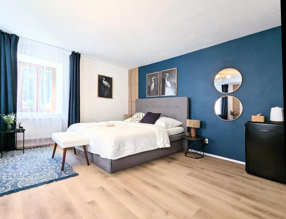 a bedroom with a bed and a blue wall at Penzion Na bezu in Drahonice