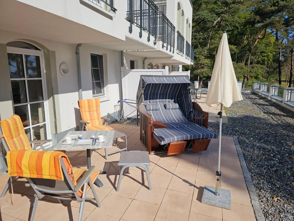 a patio with chairs and a table and an umbrella at Zum Inselparadies, Haus Meeresblick in Baabe