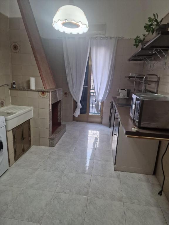 a large kitchen with a sink and a microwave at Frangio' in Noci