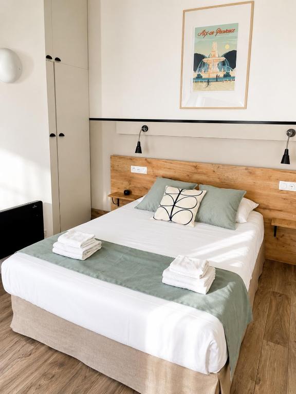 a bedroom with a large bed with a wooden headboard at Casa Stay in Aix-en-Provence
