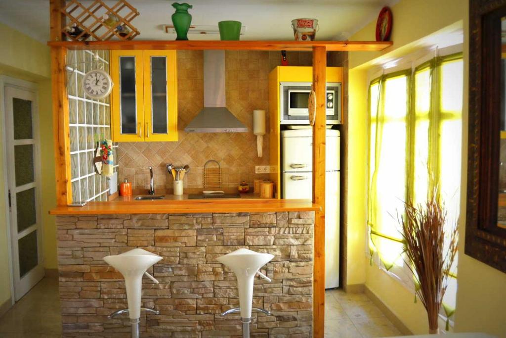 マラガにあるLa Bolsa Apartmentのキッチン(レンガ造りのカウンター、スツール2脚付)
