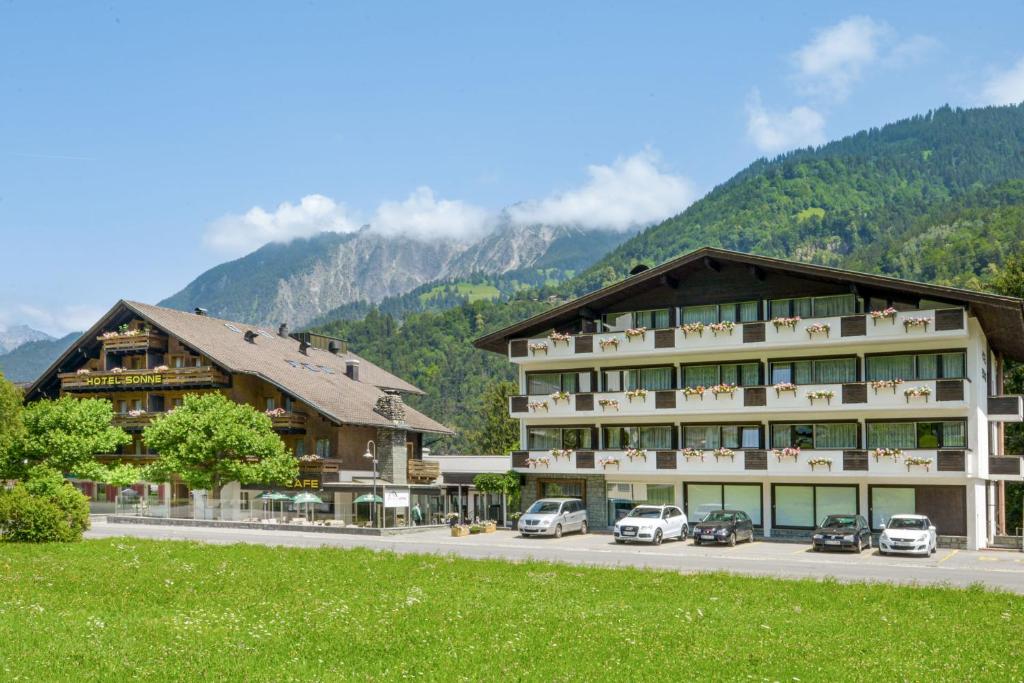 a hotel in the mountains with cars parked in front at Chalet Sonne Vandans in Vandans