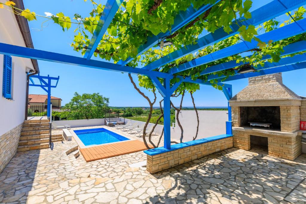 a patio with a fireplace and a swimming pool at Villa Umag Istria seaview private pool and garage by Rentistra in Umag