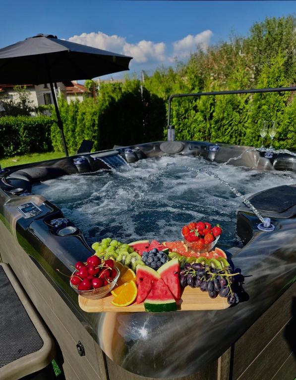 a hot tub with a tray of fruit in it at Къща Александра 2 in Dobrinishte