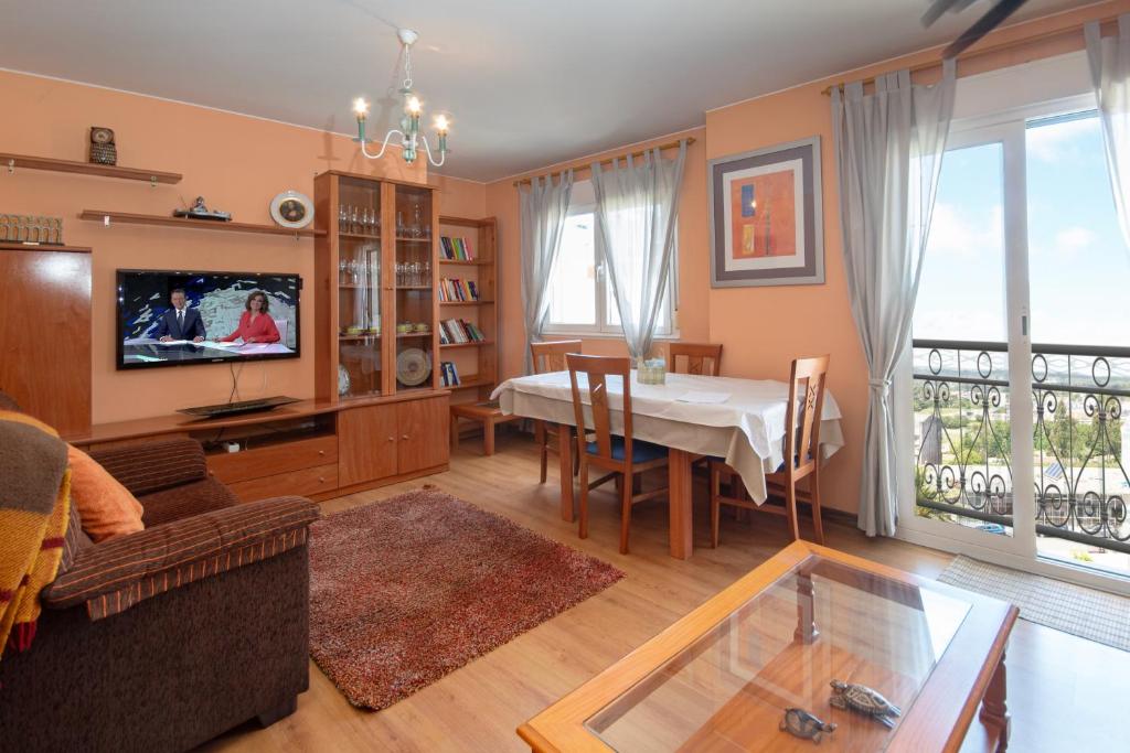 a living room with a table and a dining room at AG Piso Vazquez Parga Carballo in Carballo