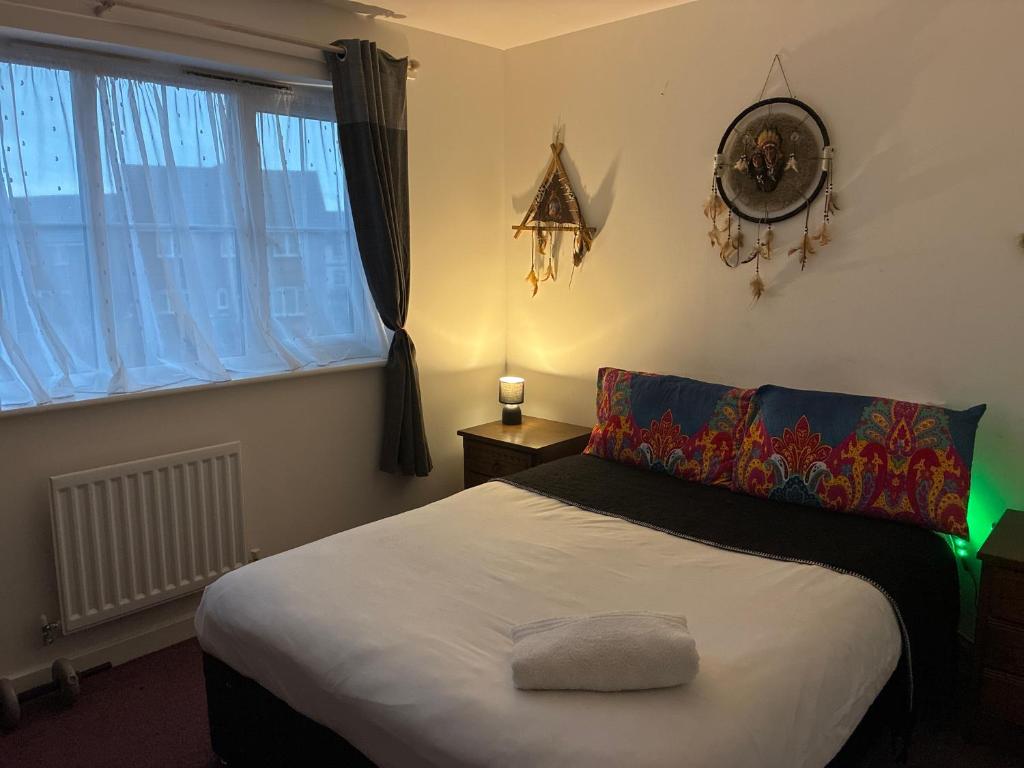 a bedroom with a bed and a clock on the wall at StaywithusHighbridge in Highbridge