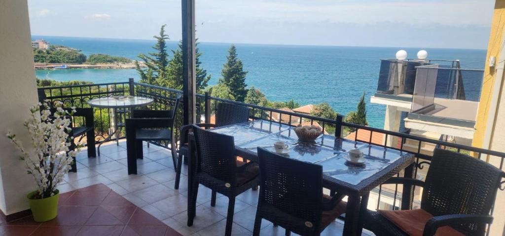 a balcony with a table and chairs and the ocean at Maca apartmani in Utjeha