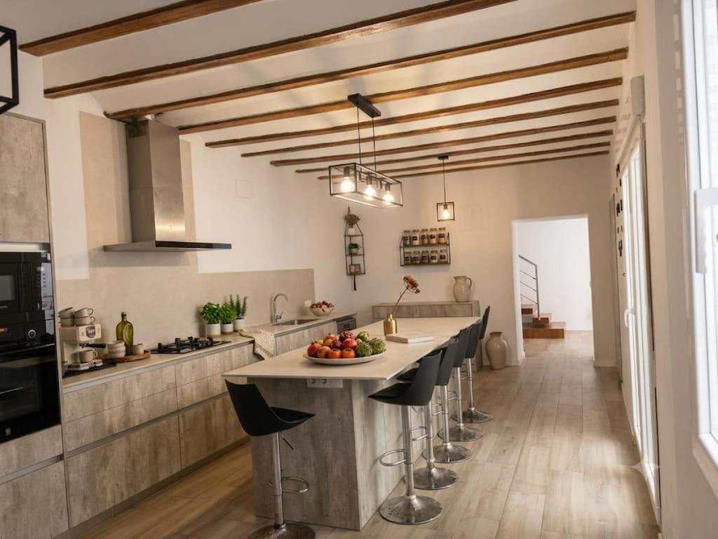 a kitchen with a long counter with stools at Casa Bethel in Chella