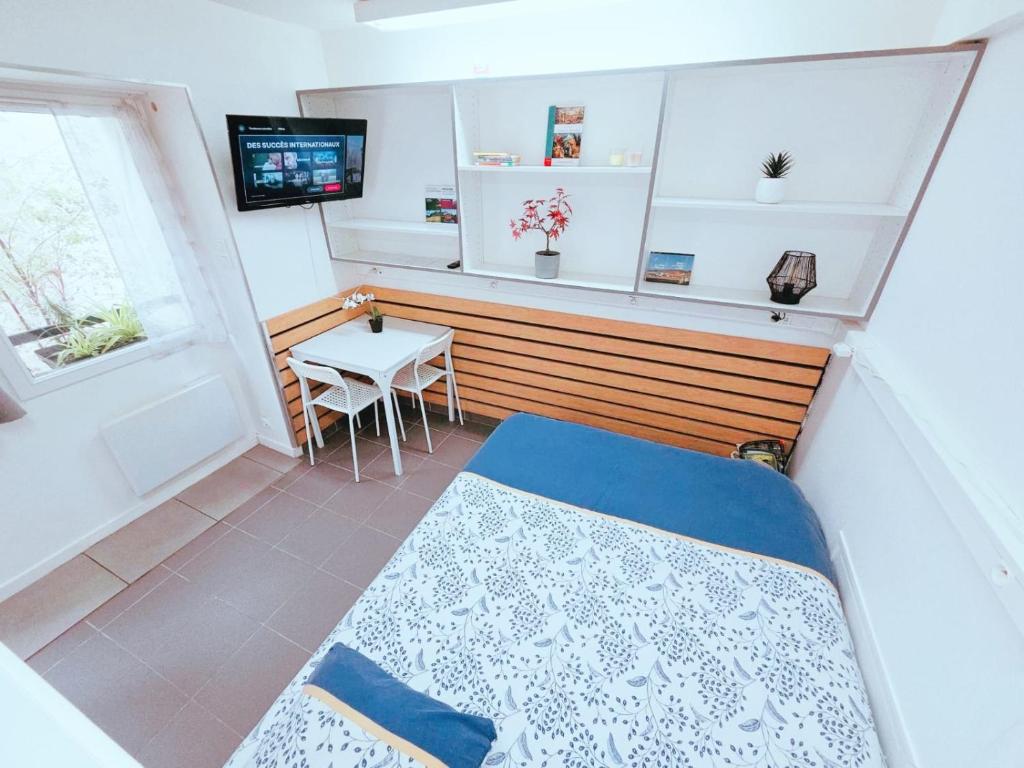 a small room with a bed and a table at Cosy logement Hyper Centre-ville in Quimper