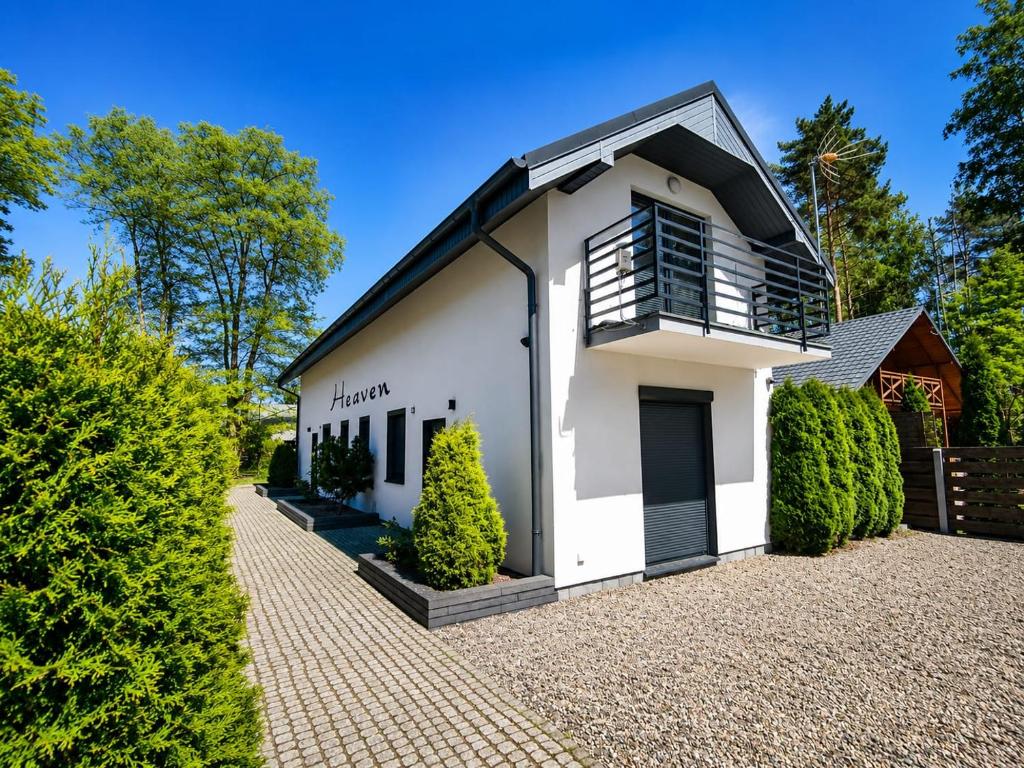a white house with a black roof at Domki Heaven Kujanki in Kujanki