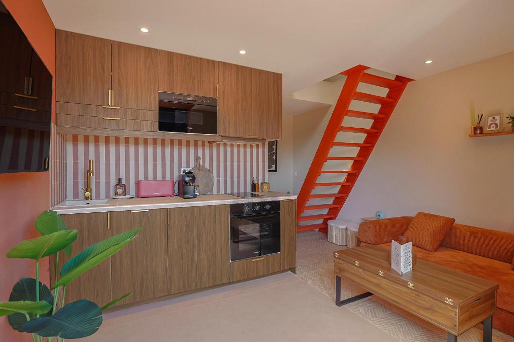 a living room with a kitchen and a staircase at LA BRISA Duplex chaleureux in Hyères