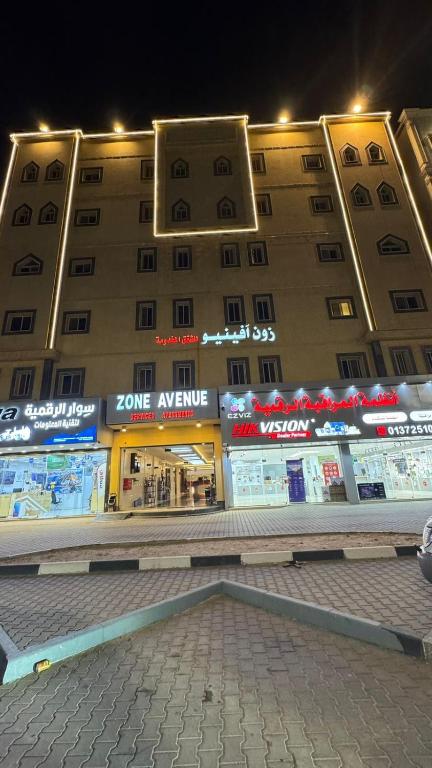 a large building with stores in front of it at night at زون آفينيو للشقق المخدومة Zone avenue in Hafr Al-Batin