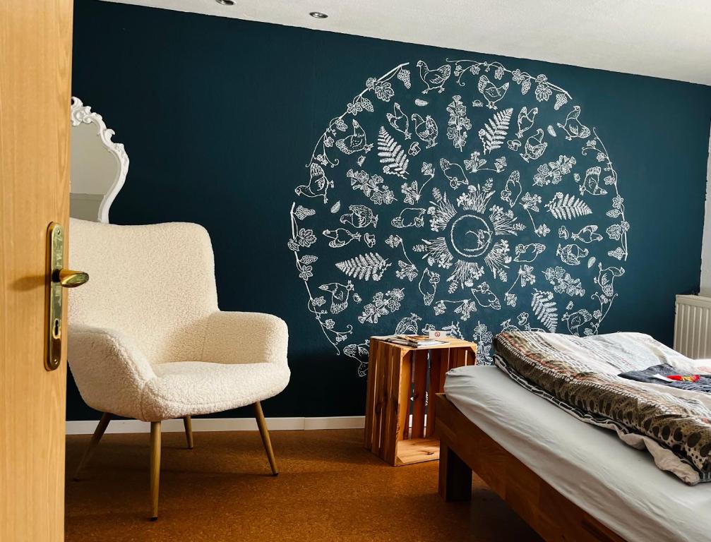 a bedroom with a chair and a blue wall at Ferienwohnung Prignitzhof in Plattenburg