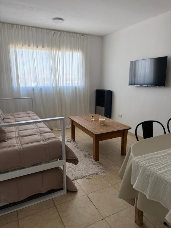 a bedroom with a bed and a table and a tableablish at Amelie 4 in General Roca