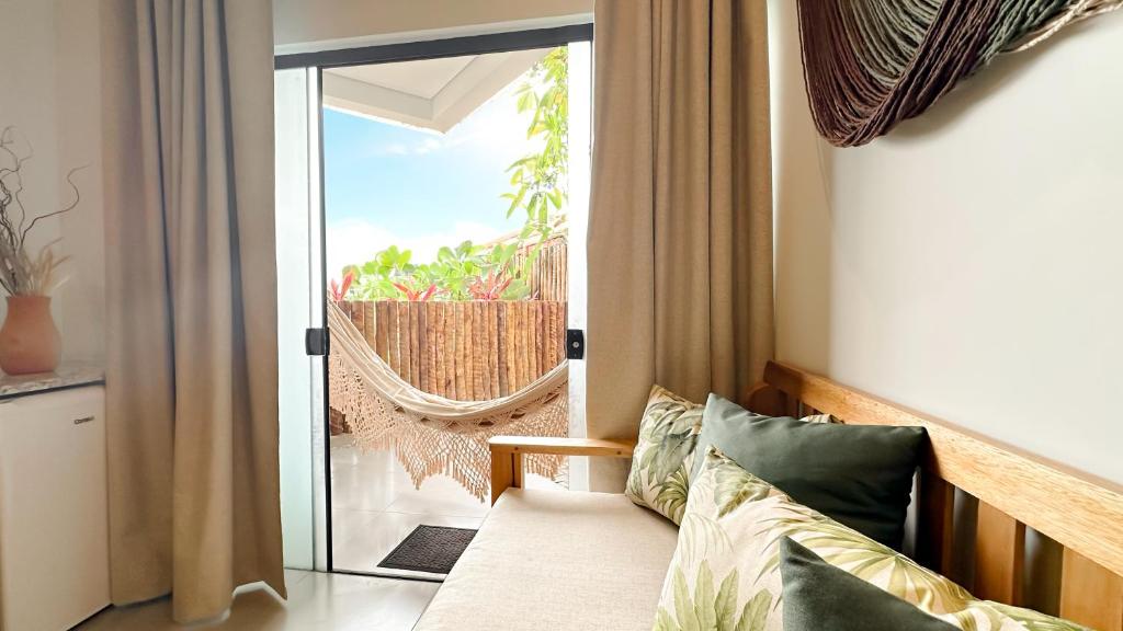 a living room with a couch and a sliding glass door at Mirante das Conchas - Melhor Localização in Itacaré