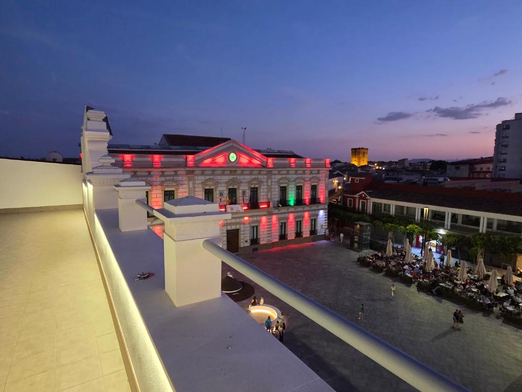 a building with red lights on it at night at Plaza España AT in Alcazar de San Juan