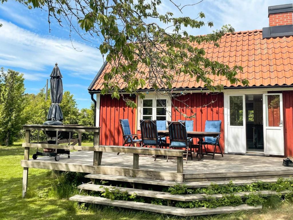 a red cottage with a table and chairs on a deck at 4 star holiday home in TORHAMN-By Traum in Torhamn