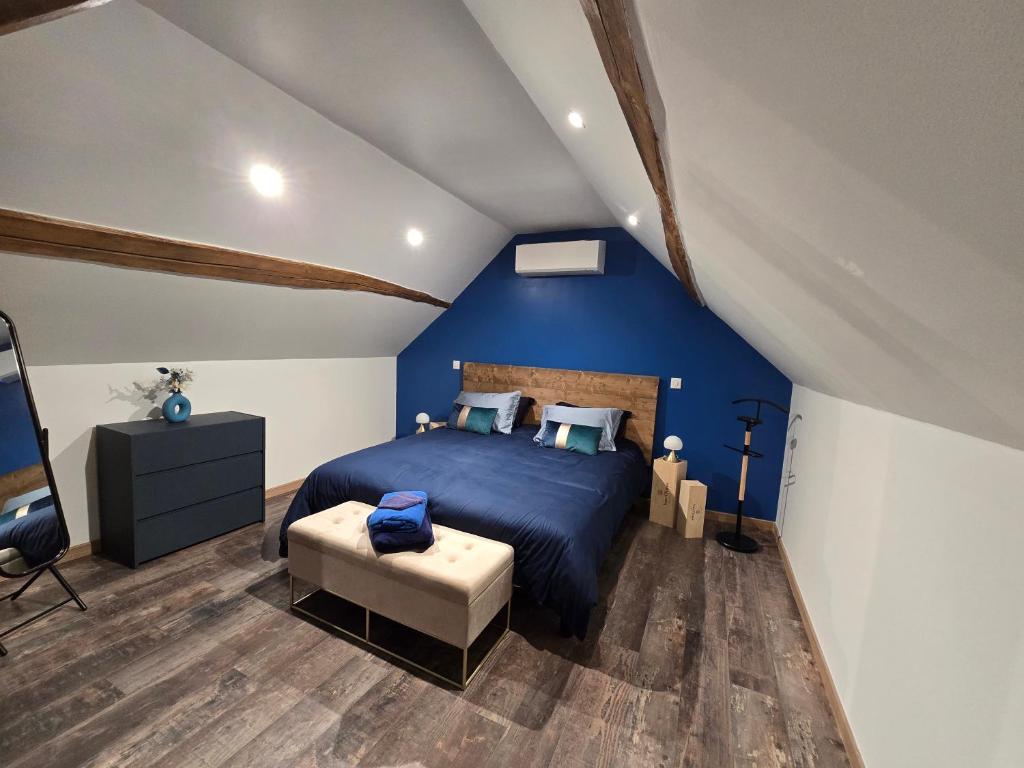 a blue bedroom with a bed and a chair at Sarments et Bulles in Ambonnay