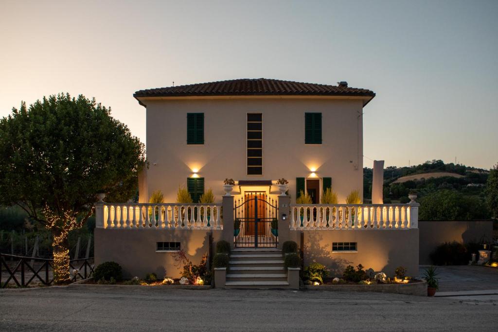 a large white house with a gate and stairs at Villa Scarpino in Massignano