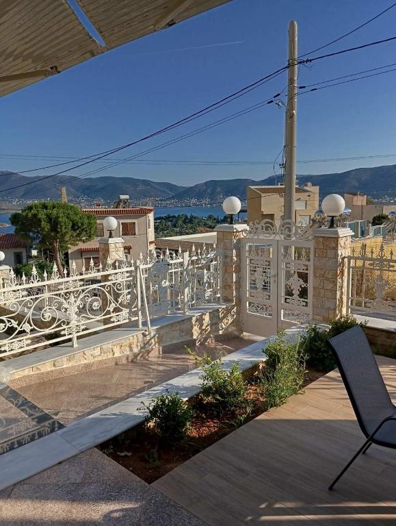 a balcony with a white fence and a chair at stavros house byzarkco in Porto Rafti