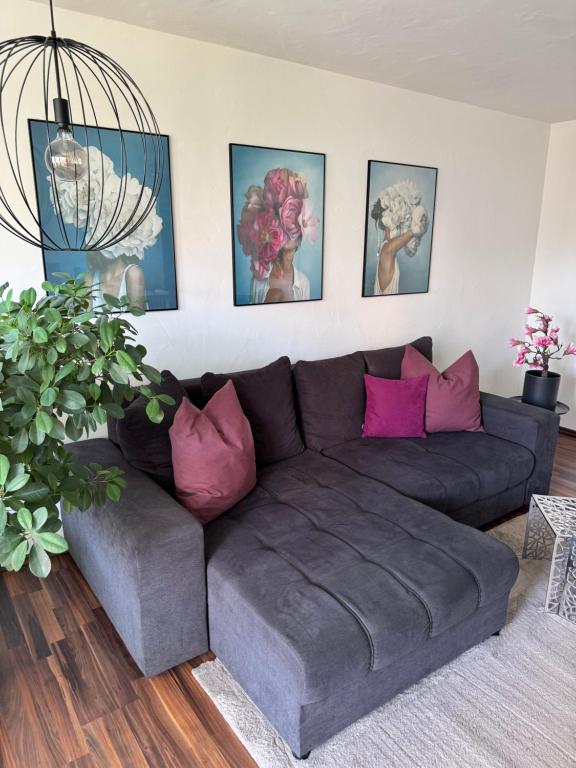 a living room with a brown couch and pink pillows at Ferienwohnung Homburger - Immenstaad am Bodensee in Immenstaad am Bodensee