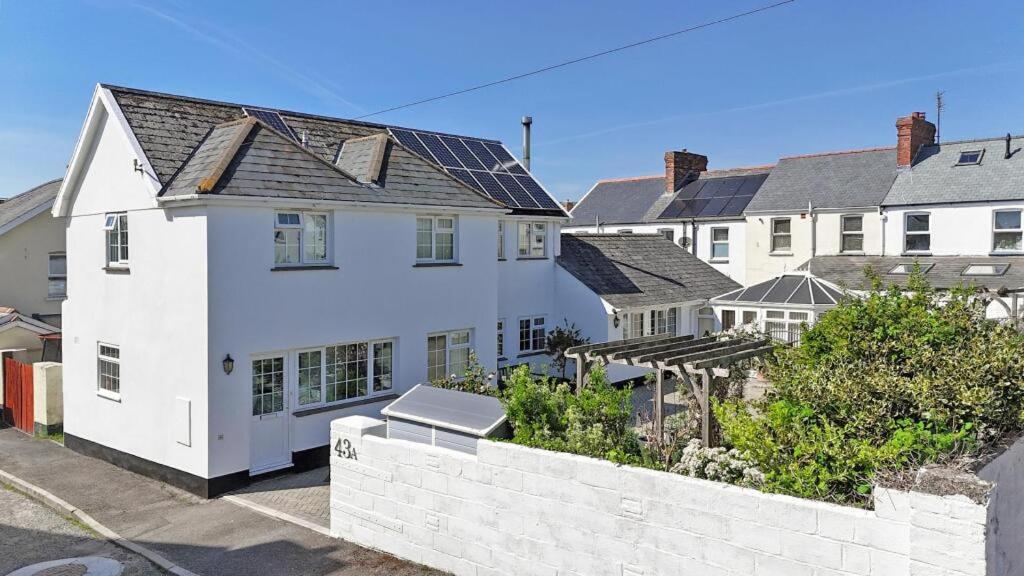 a white house with a white wall at The Coach House in Braunton