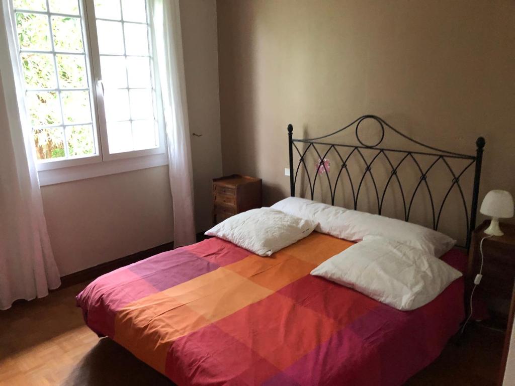 a bedroom with a large bed with a colorful blanket at Ciboure in Ciboure