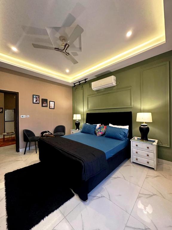 a bedroom with a blue bed and a green wall at River Hill in Rawalpindi