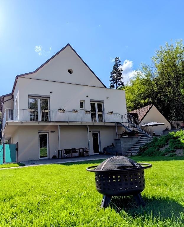 a white house with a grill in the yard at Apartmány v Propadání in Jedovnice
