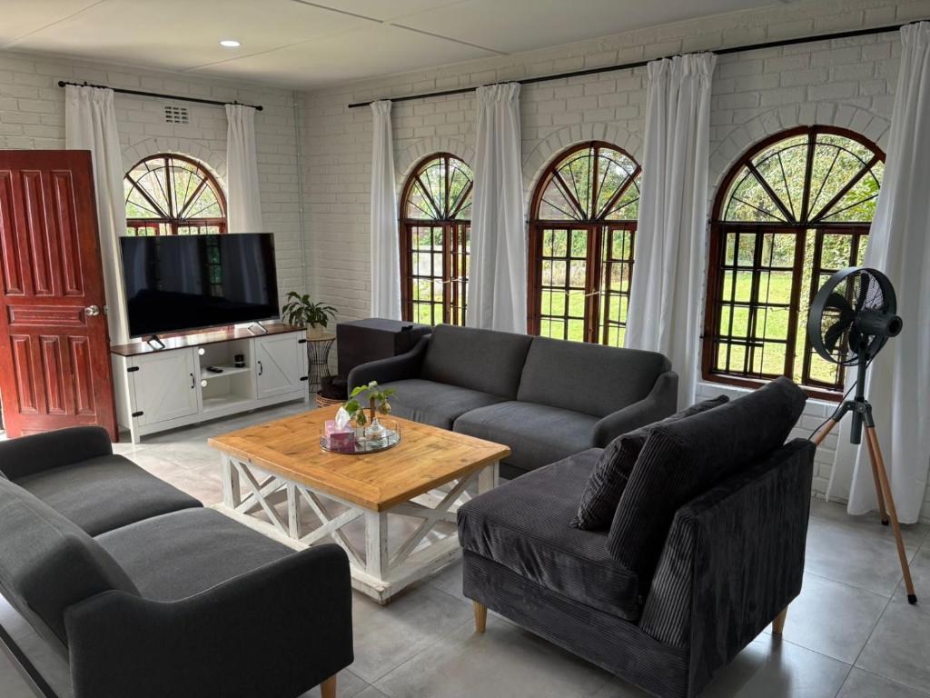 a living room with couches and a tv and a table at 19 on Amber in Ugie