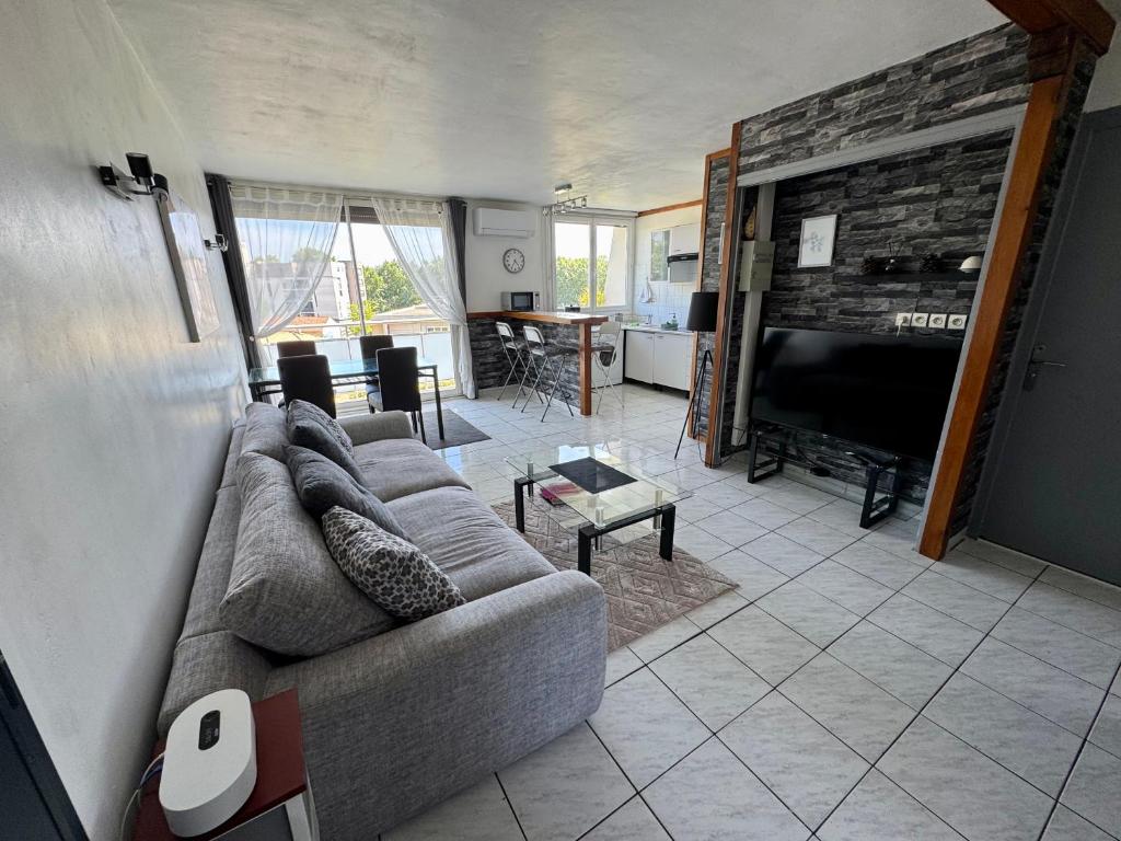 a living room with a couch and a television at Appartement Port Marianne Montpellier in Montpellier