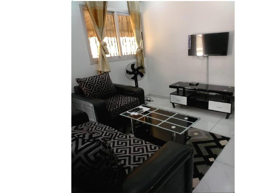 a living room with two chairs and a coffee table at Résidence ADJOBIA - Grâce divine YAMOUSSOUKRO in Yamoussoukro