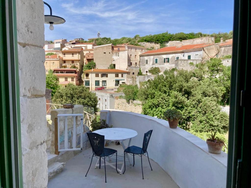 a table and chairs on a balcony with a view at Pedra e Lozzu in Sedini
