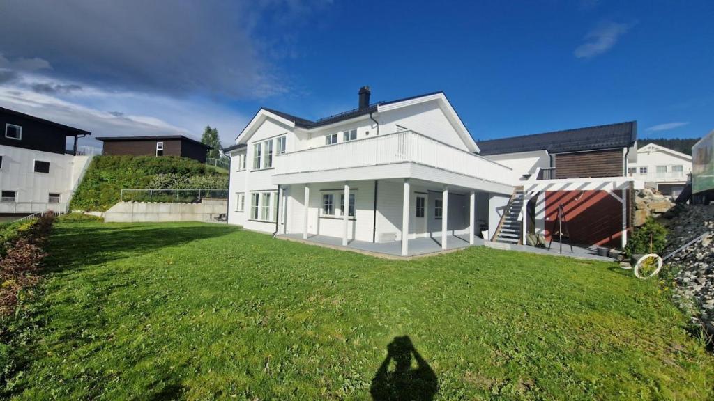 a large white house on a green lawn at Villa Modum in Skreppen