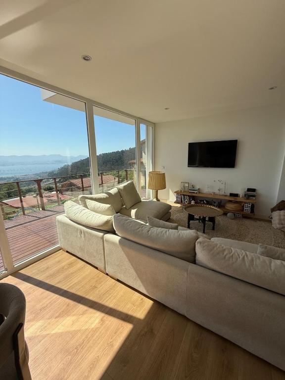 a living room with a large couch and a television at Casa Broullón in Moaña