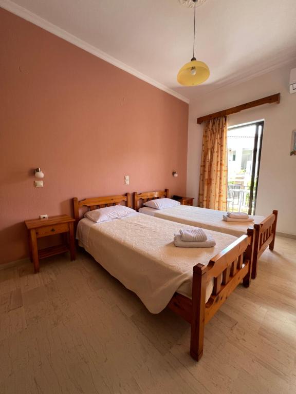 a bedroom with two beds and a window at Hotel Omirico in Gouvia