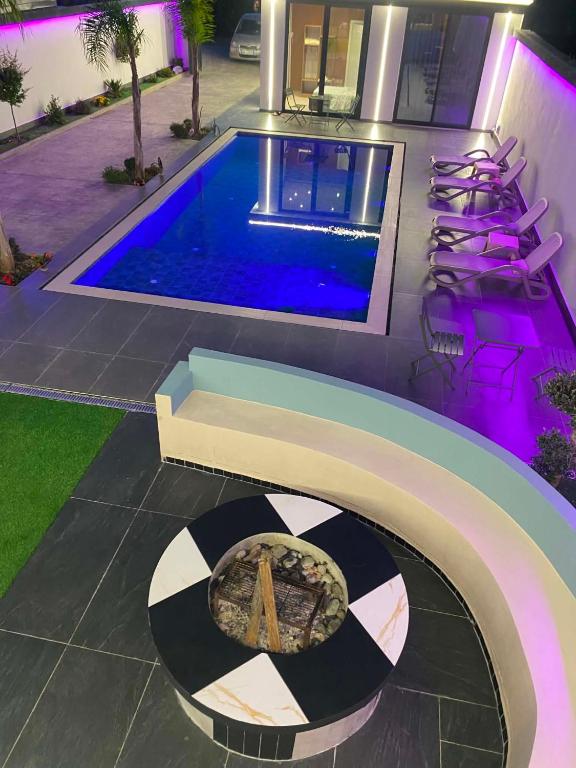 a house with a swimming pool and a table with a pizza at Aurora villa in Rrushkull