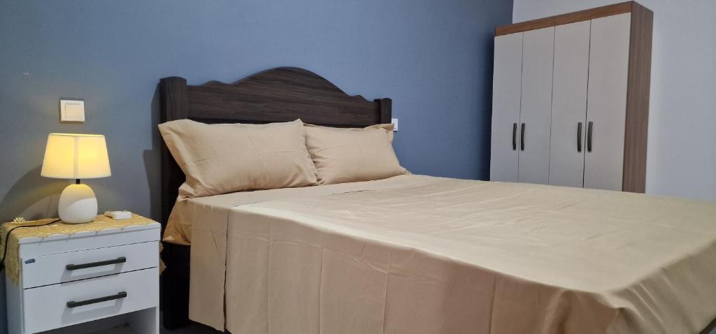 a bedroom with a bed and a nightstand with a lamp at Kaza Branka in Sal Rei