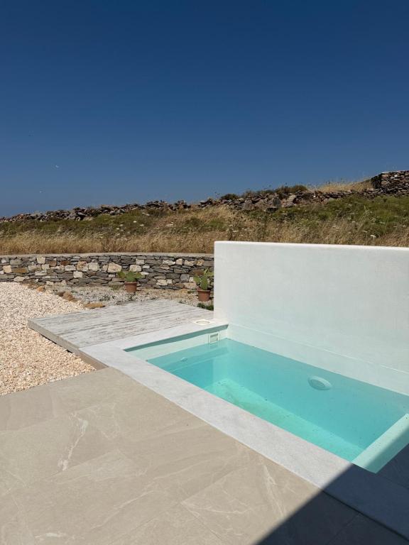 a swimming pool sitting on top of a patio at Gaia Elysian Sea View New Golden Beach Piso Livadi in Kampos Paros