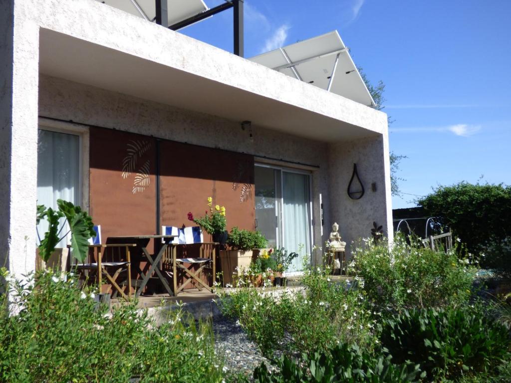 a house with a table and chairs in front of it at Almahue in Quebrada de los Pozos