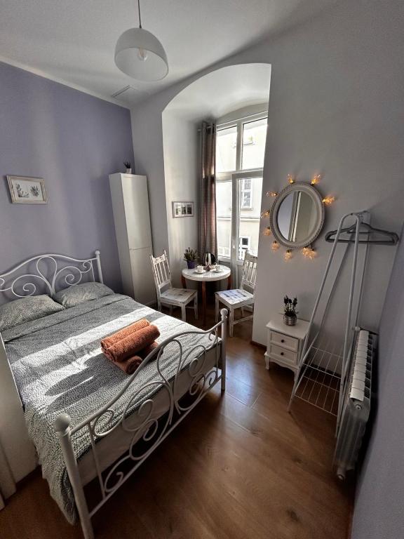 a bedroom with a bed and a mirror and a table at Prowansalski Sen - pokój z łazienką nr 3 in Poznań