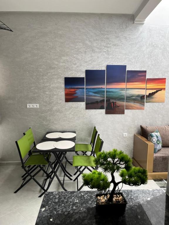 ein Wohnzimmer mit einem Tisch und einem Gemälde an der Wand in der Unterkunft Dar DADA-Aglou in Tiznit