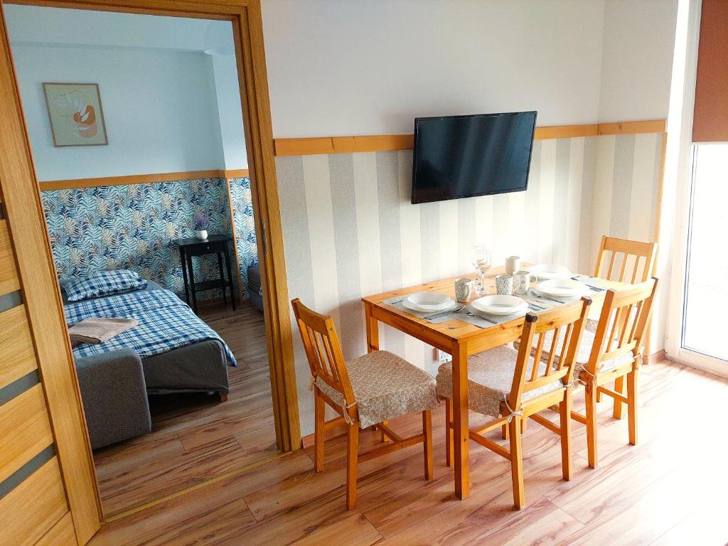 a dining room with a table with chairs and a mirror at Apartament Janka in Zator