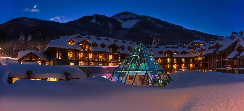 a christmas tree in the snow in front of a hotel at Val Di Luce Spa Resort in Abetone